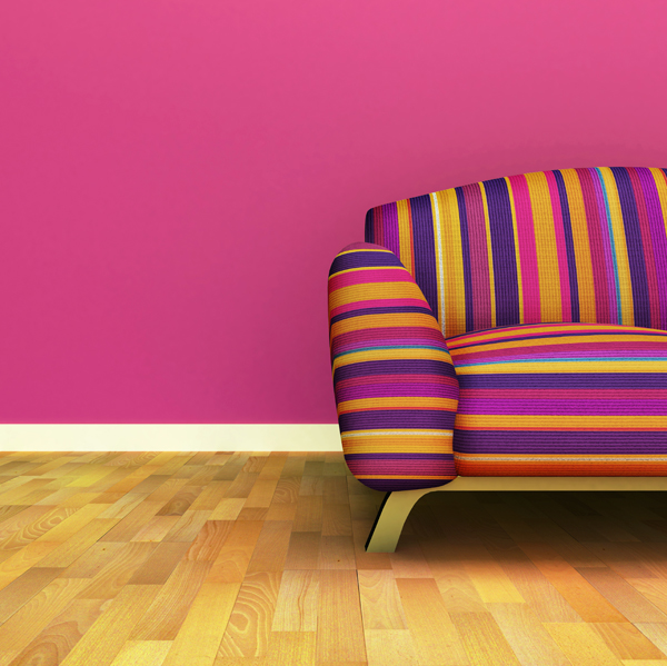 Brightly striped sofa against a pink wall